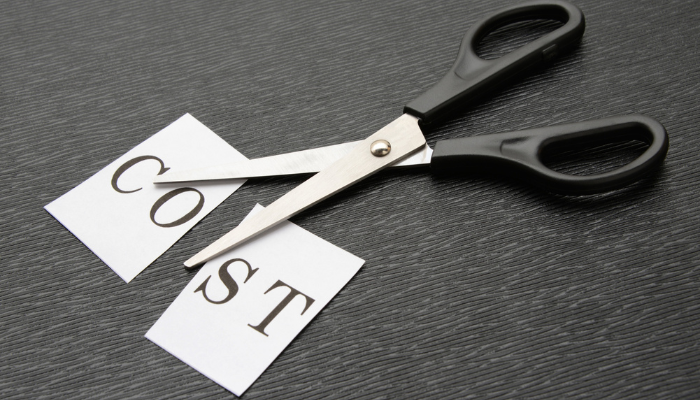 Scissors cutting the word cost to represent reducing business expenses carefully