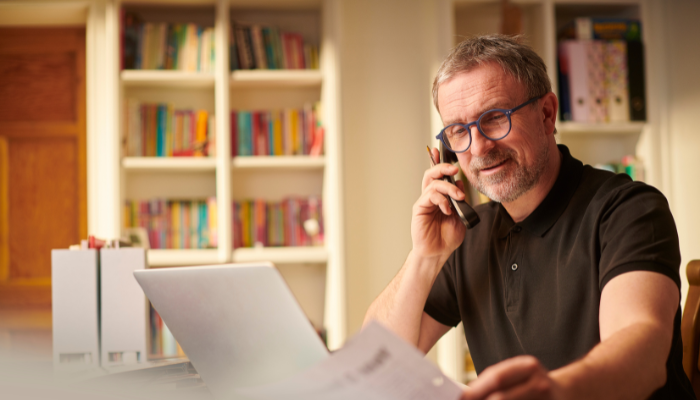 Business owner reviewing invoices and discussing payment status over the phone.