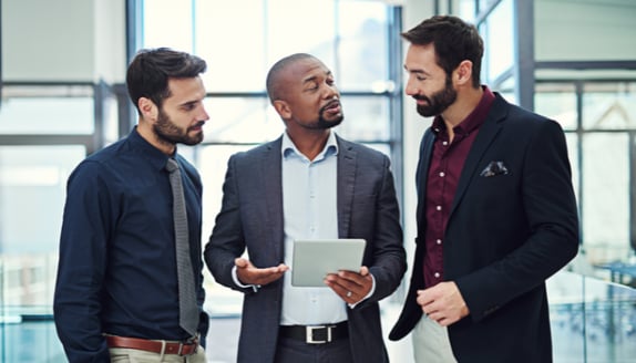 Business professionals reviewing financial options on a tablet, illustrating collaboration between banks and alternative lenders.