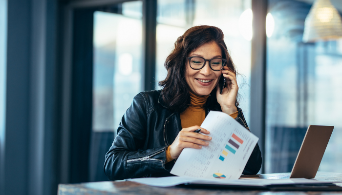 Professional on phone reviewing financial charts and organizing year-end tasks