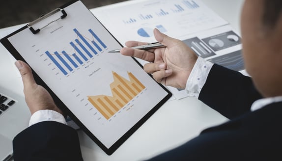 Business professional analyzing financial charts to evaluate revenue trends and cash flow performance.