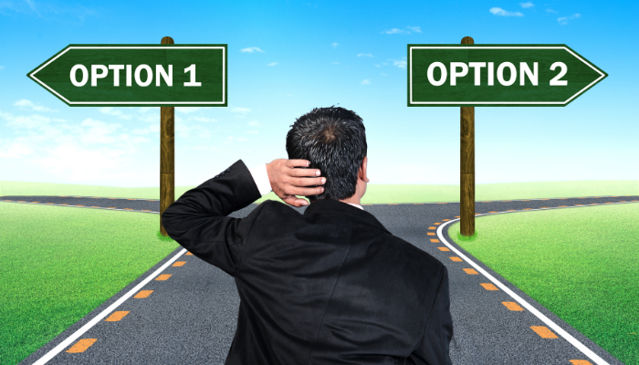 A business owner standing at a crossroads between Option 1 and Option 2, representing how many companies prefer both bank support and factoring flexibility rather than choosing one.