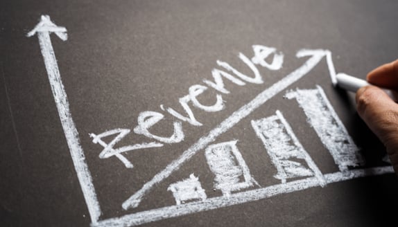 Revenue growth chart drawn on a chalkboard, showing increasing sales that do not always translate into immediate cash flow.