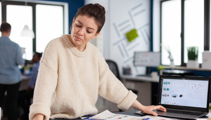 Start-up business owner reviewing financial documents while managing cash flow and planning for growth.