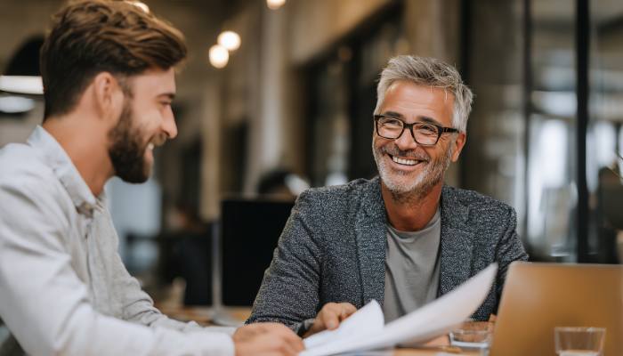 Experienced business advisor smiling while reviewing documents with a small business owner client