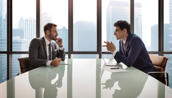 Two business professionals discussing invoice assignment notice across a conference table