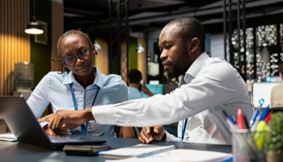 Two business professionals reviewing payment information together during a factoring-related process update