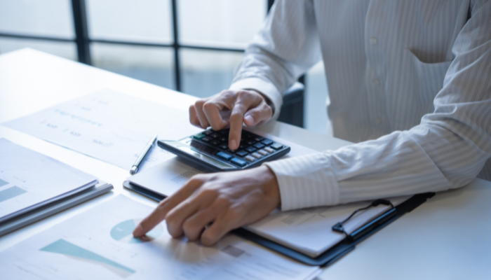Business professional reviewing financial documents and a calculator while evaluating accounts receivable financing