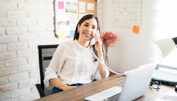 Small business owner confidently calling a customer to explain a factoring payment change
