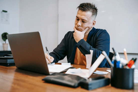 Staffing agency owner reviewing financial documents and cash flow projections while evaluating funding options to support business growth.