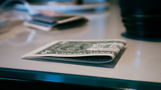 Cash on a desk representing immediate liquidity and working capital support for businesses managing delayed customer payments through invoice factoring.