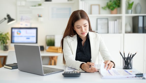 Business professional reviewing payment documents and updating records during a factoring-related payment process