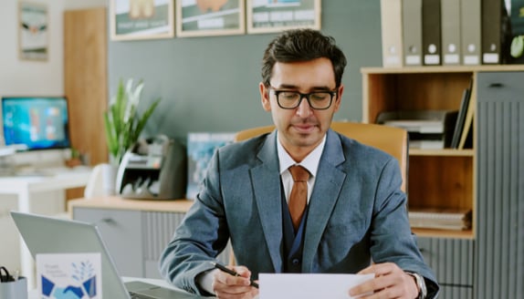 Business professional reviewing payment paperwork carefully before responding to a factoring-related update