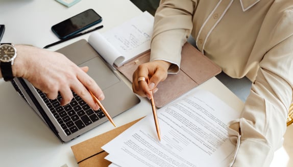 Business professionals reviewing payment paperwork together as part of a routine factoring-related process update