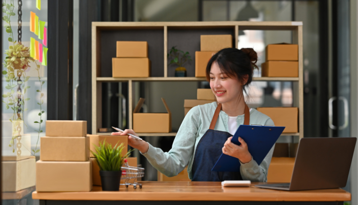 Small business owner reviewing orders and inventory while managing cash flow needs